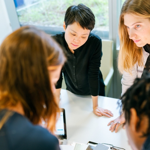 People standing at a table collaborating